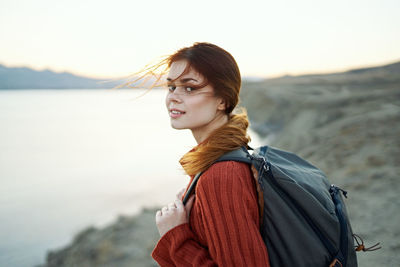 Portrait of woman standing by sea against sky