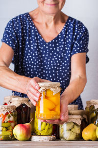 Midsection of woman standing by fruits