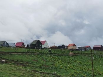 Houses on field against sky