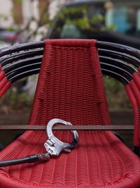 Close-up of a stack of empty red outdoor seats, locked up with handcuffs