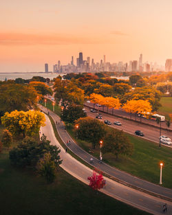 High angle view of street by buildings against sky during sunset