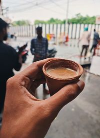 Midsection of man holding coffee cup