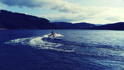 Man on boat in sea against sky