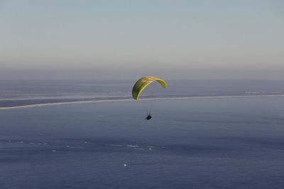 Person paragliding against sky