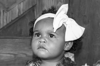 Close-up of cute baby girl looking away