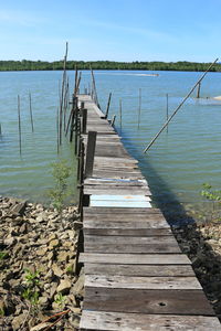 Wooden pier over lake against sky