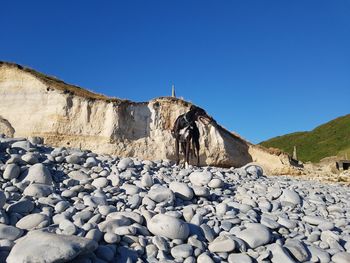 Scenic view of rocks against clear blue sky