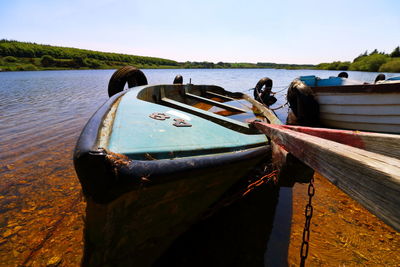 Boat moored on beach against sky