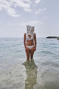 Woman in sea against sky