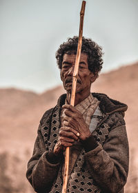 Senior man holding stick standing outdoors
