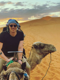 Young man wearing sunglasses on land against sky