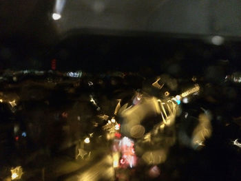 People at illuminated city seen through airplane window at night