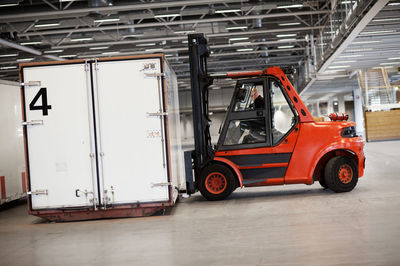 Man driving forklift truck in warehouse in warehouse