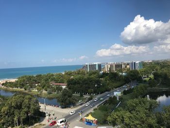 High angle view of city by sea against sky