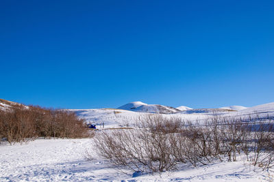 Scenic view of snowcapped mountains against clear blue sky