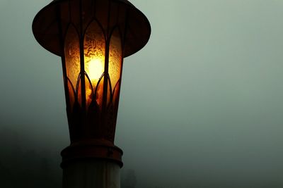 Low angle view of illuminated street light against sky