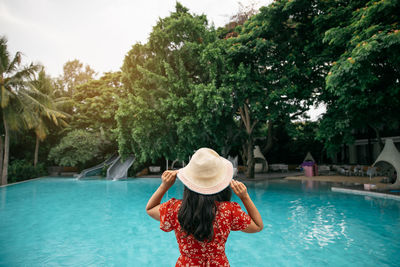 Rear view of woman wearing hat against swimming pool