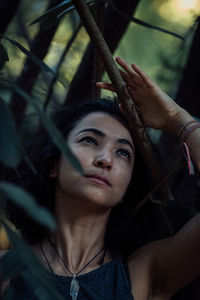 Portrait of a young woman holding plant