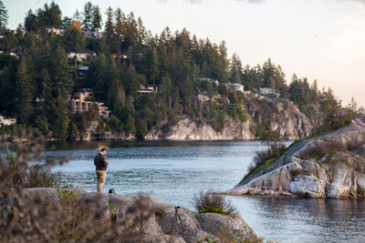 Rear view of man standing by lake