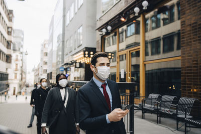 Man standing in front of office buildings