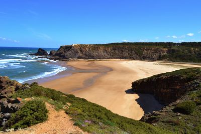 Scenic view of beach and sea against blue sky