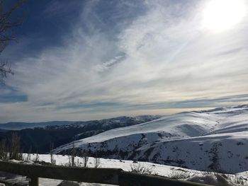 Scenic view of snow covered mountain against cloudy sky