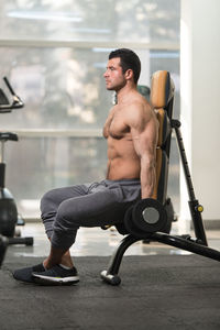 Shirtless muscular man exercising in gym