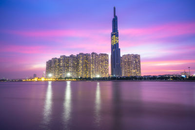 Illuminated buildings against sky at sunset