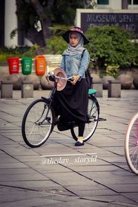 Portrait of man riding bicycle on footpath