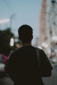 Rear view of man standing on street in city