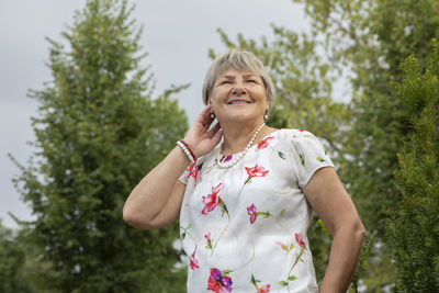 Portrait of young woman standing against plants