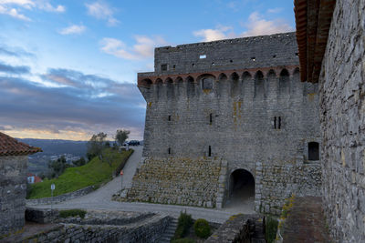 Low angle view of old ruin building against cloudy sky