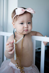 Close-up portrait of cute shirtless baby girl wearing jewelries and headband