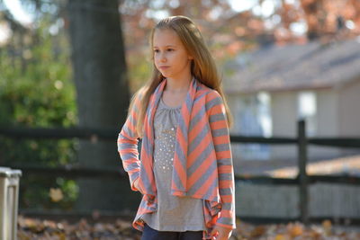 Blond girl standing at back yard