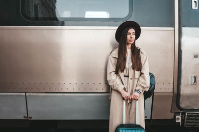 Portrait of woman standing against wall