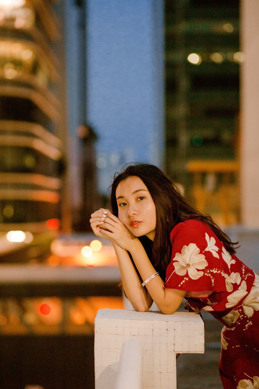 women, one person, flower, young adult, flowering plant, real people, leisure activity, lifestyles, young women, focus on foreground, portrait, waist up, plant, holding, sitting, illuminated, adult, front view, beautiful woman, hairstyle, outdoors, contemplation