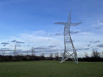 Low angle view of windmill on field against sky