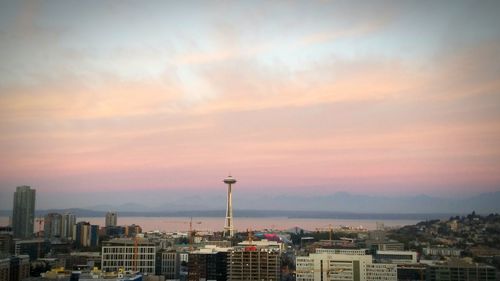 View of cityscape against cloudy sky