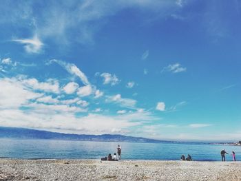 People on beach against sky