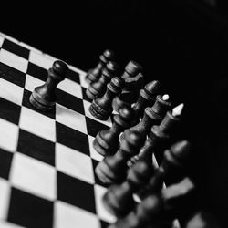 Close-up of chess pieces on board against black background