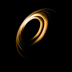 Close-up of spiral light over black background