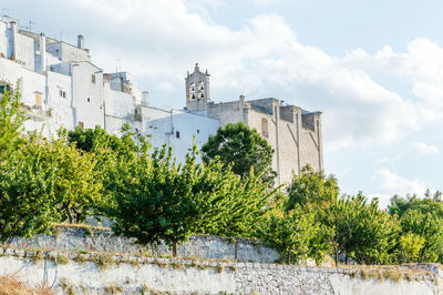 Low angle view of trees and buildings against sky