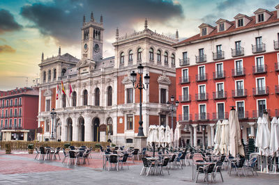 Buildings in city against cloudy sky