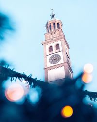 Low angle view of clock tower amidst buildings against sky