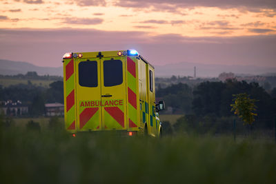 Yellow ambulance car of emergency medical service on country road. 