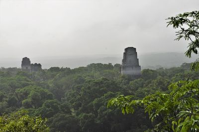 Tikal ruins by trees against sky