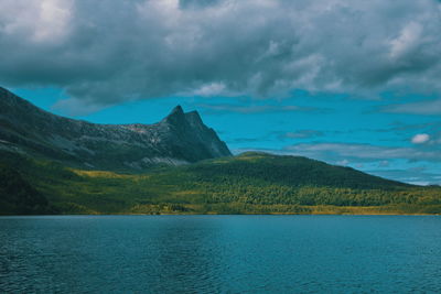 Scenic view of lake by mountains against sky