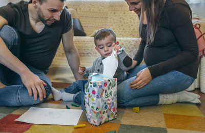 Parents playing with son while sitting at home