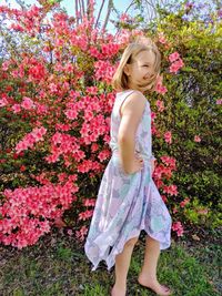 Girl standing by pink flower tree