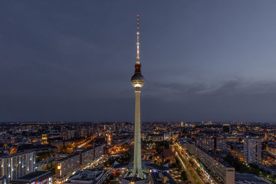 Illuminated buildings in city against sky